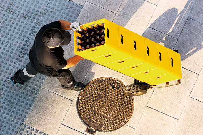 Ein Mann fährt mehrere Getränkekästen auf einer Sackkarre